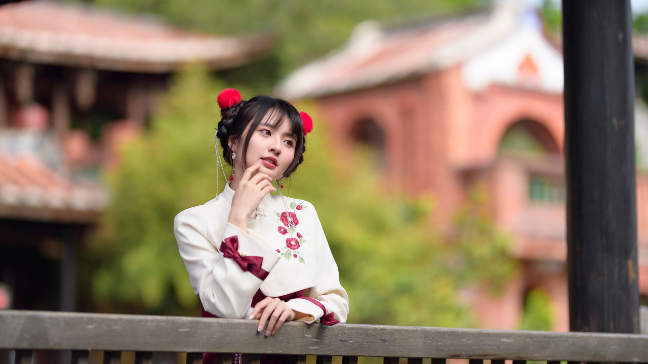 Девушка азиатка в народном костюме стоит у перил