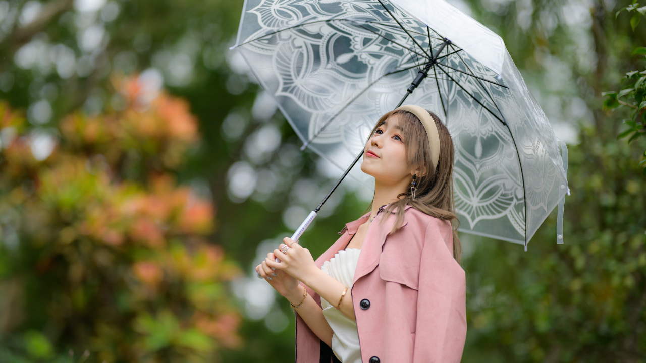 Девушка азиатка в пальто под прозрачным зонтом
