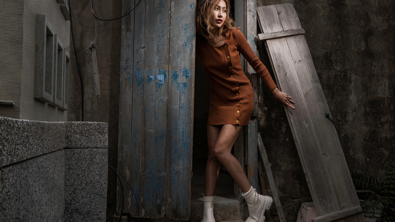 Девушка азиатка в коричневом платье у старого дома