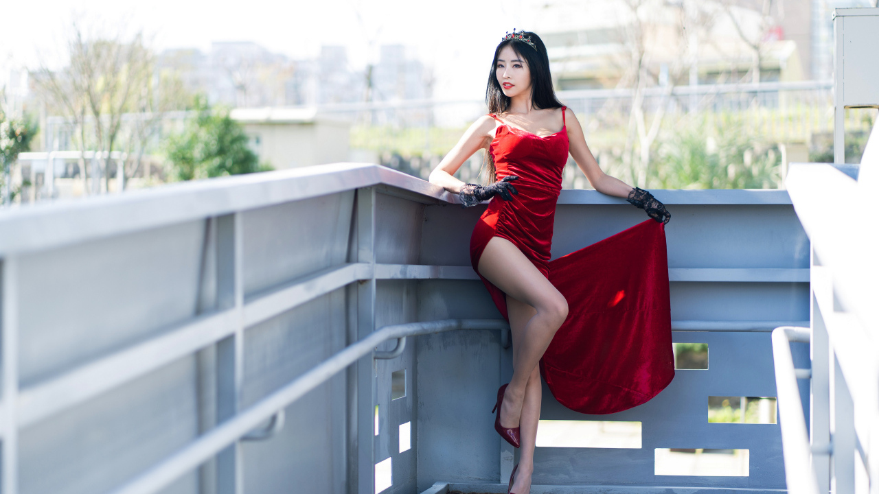 Азиатка в красном платье с короной на голове