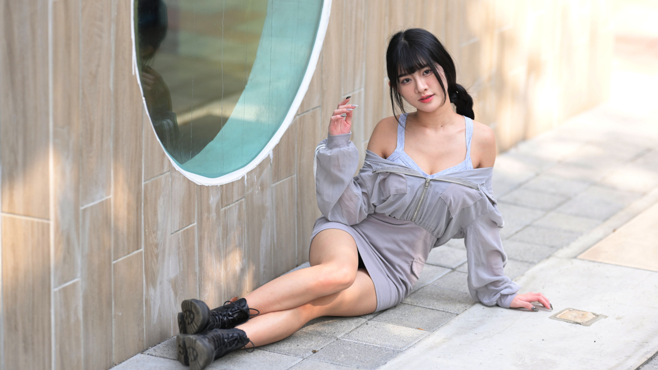 Азиатка лежит на полу у окна