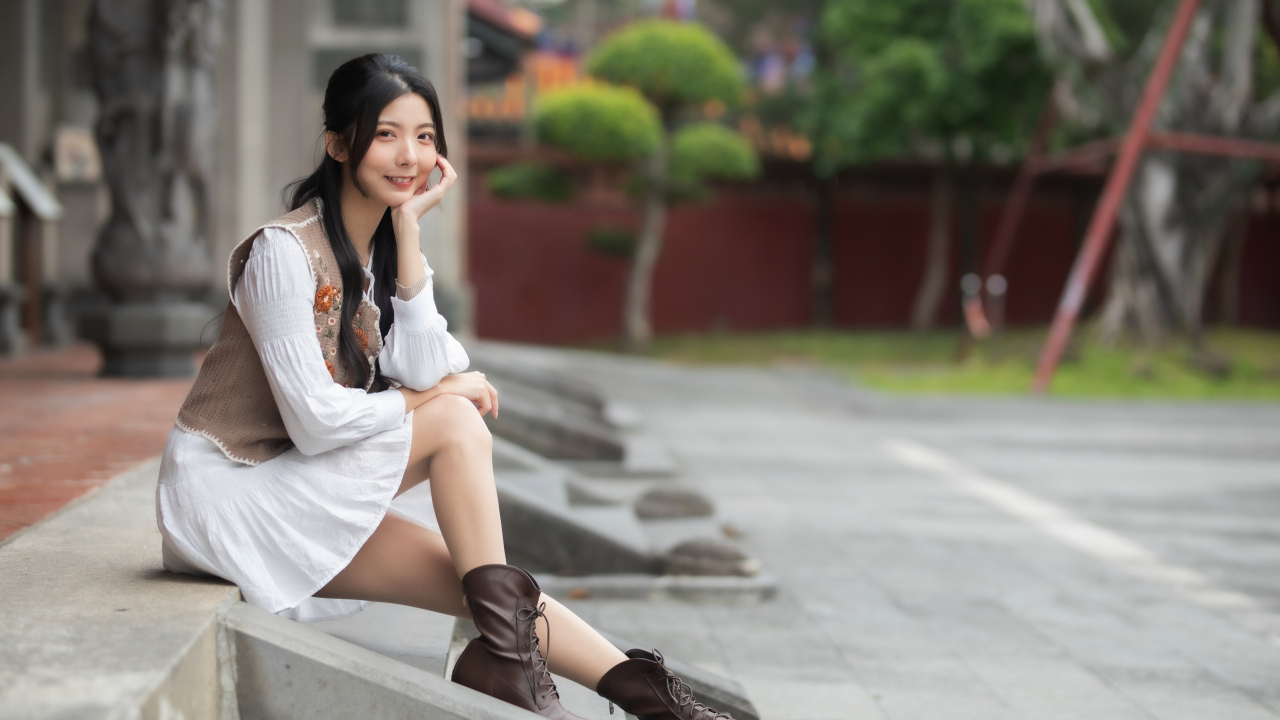 Азиатка сидит на холодных ступеньках