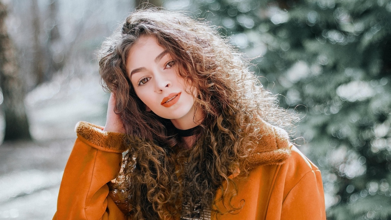 Красивая девушка с кудрявыми волосами и карими глазами