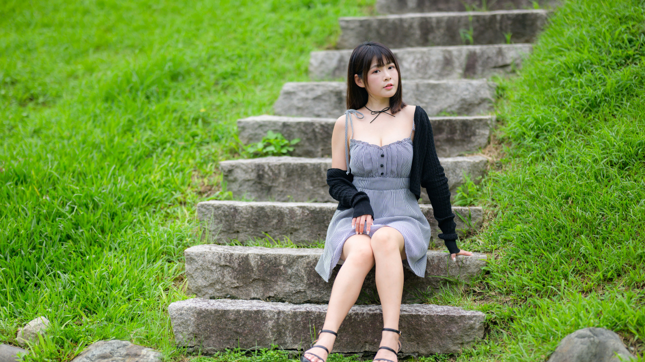 Красивая молодая девушка азиатка сидит на ступеньках