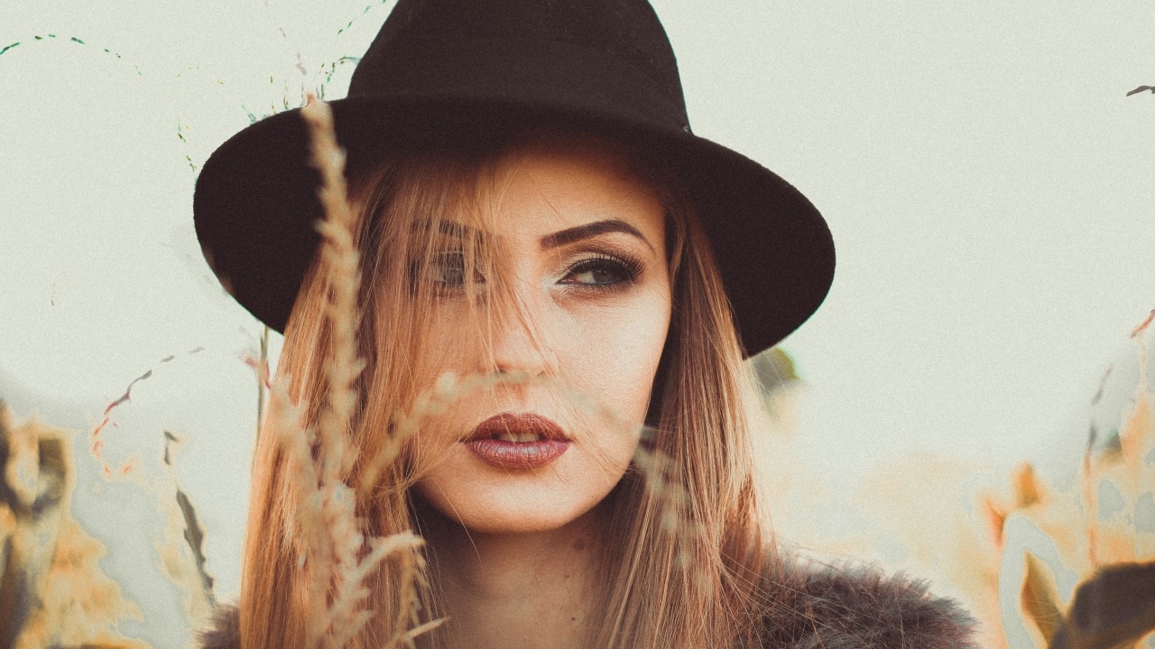 Серьезная девушка в черной шляпе 