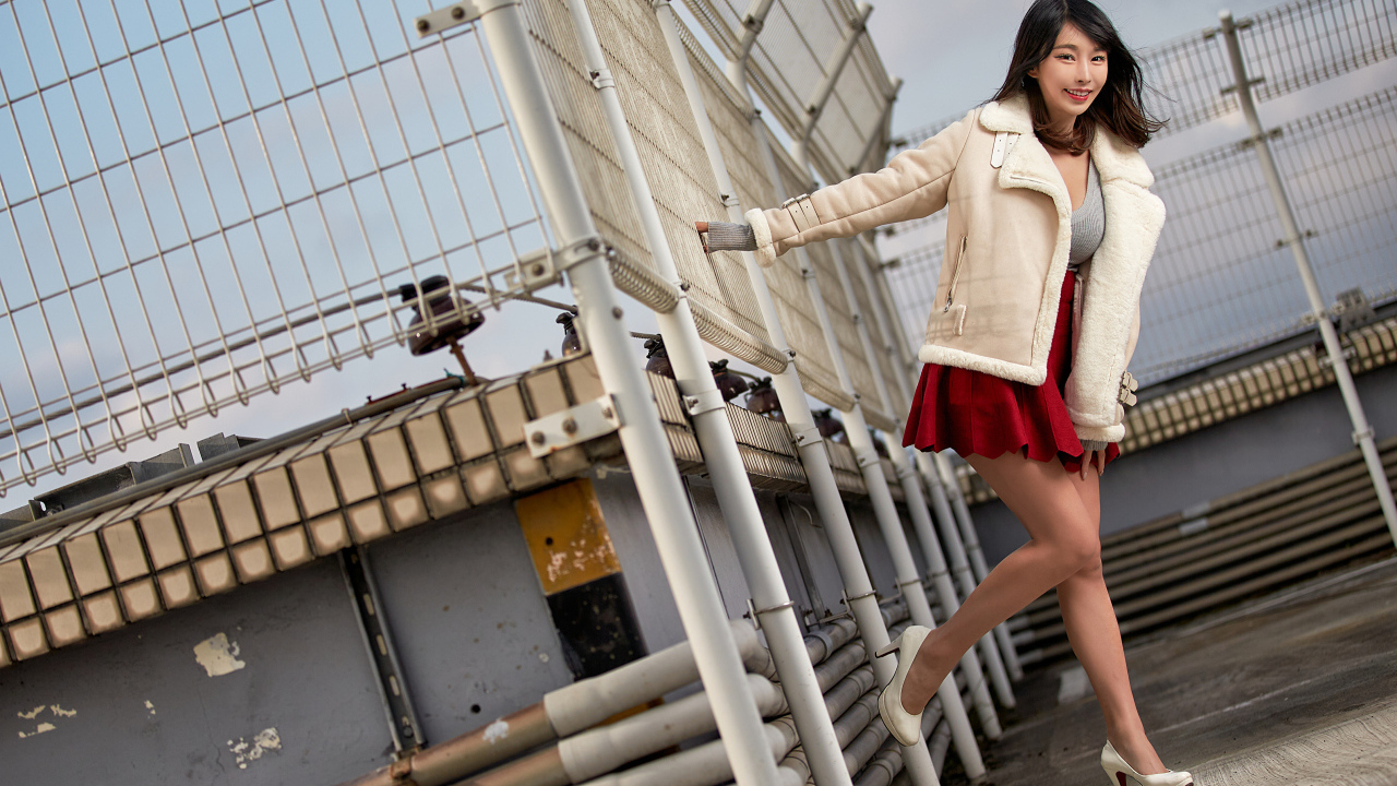 Улыбающаяся девушка азиатка в теплой куртке