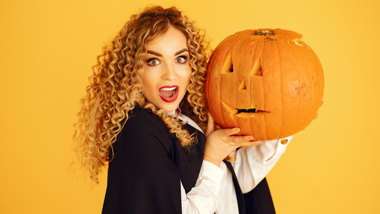 Удивленная девушка с тыквой на Хэллоуин