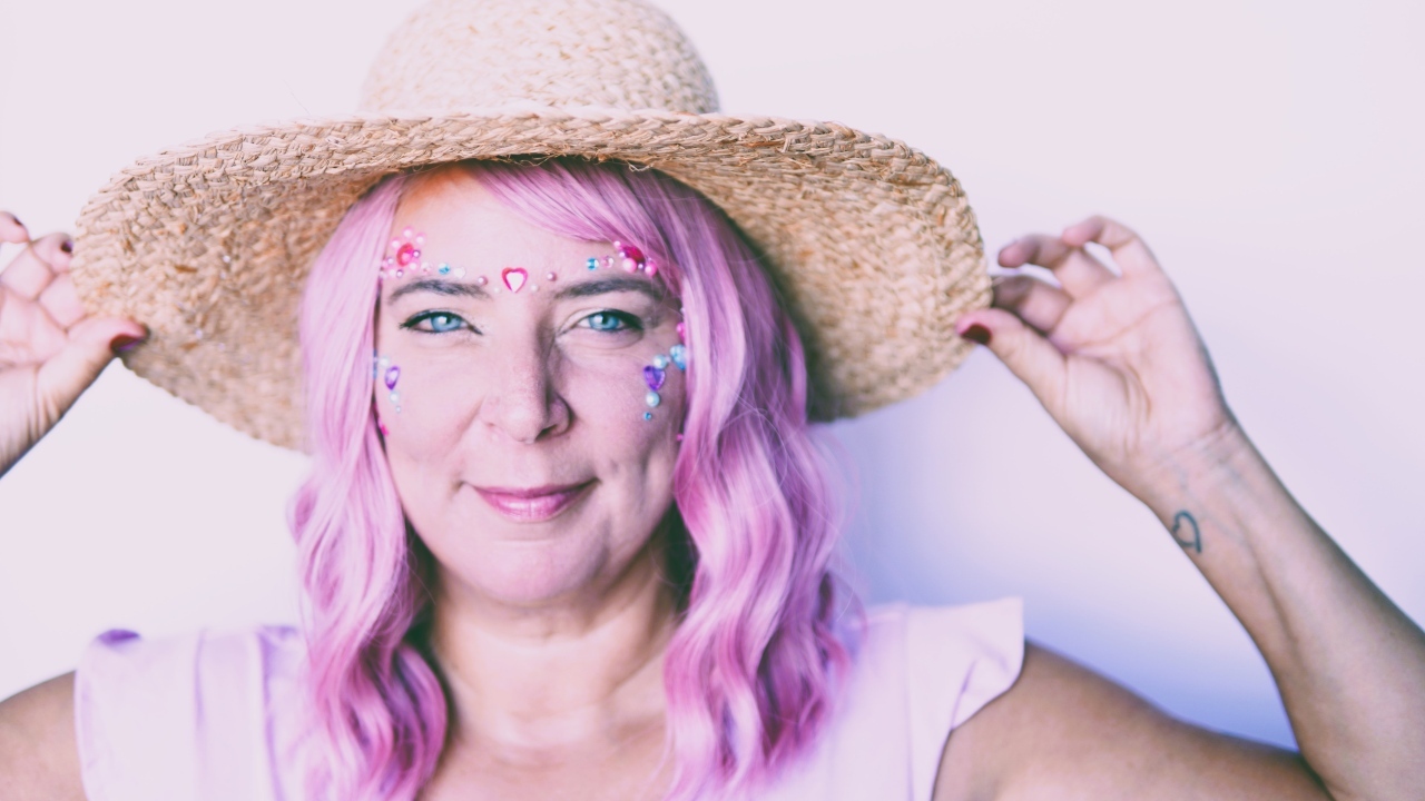Женщина в шляпе с розовыми волосами