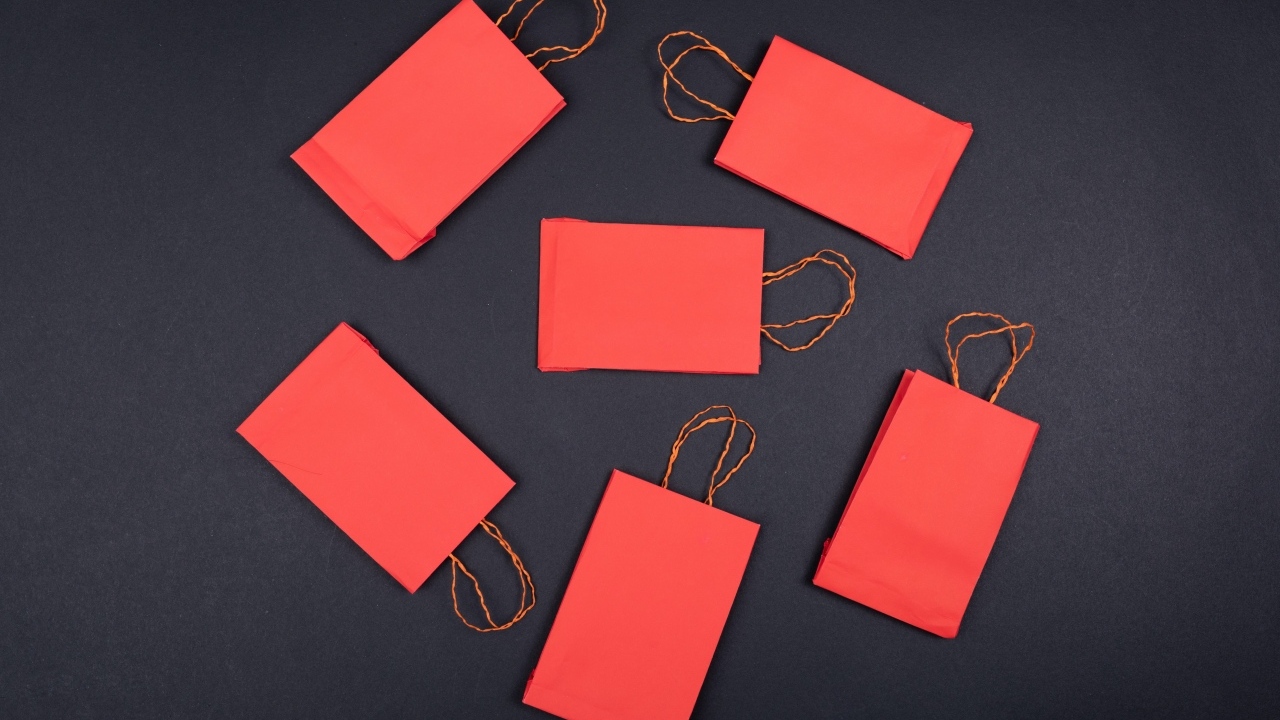 Красные пакетики для подарков на черном столе