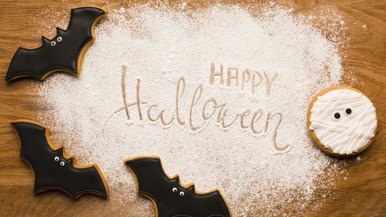 Cookies in the shape of bats on a cutting board for Halloween