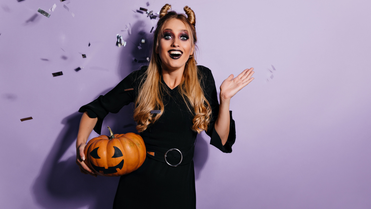 Девушка в черном костюме с тыквой на праздник Хэллоуин