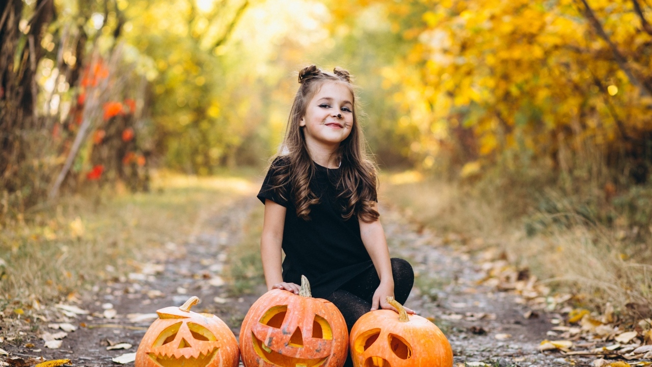 Девочка с тыквой в парке на праздник Хэллоуин