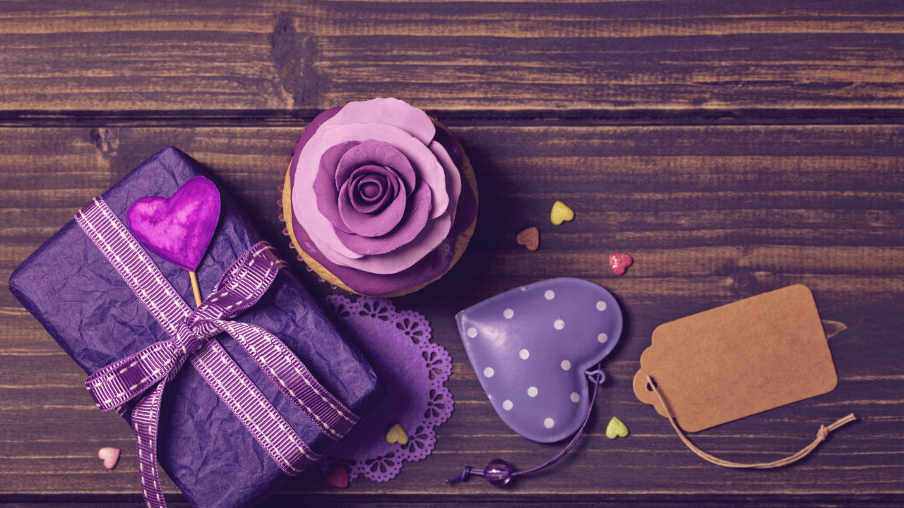 Подарок рядом с кексом, сердечком и открыткой