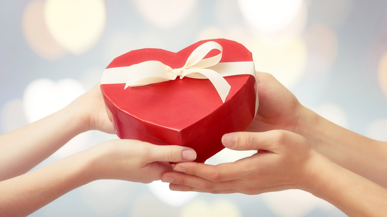Коробка в форме сердца в руках у пары