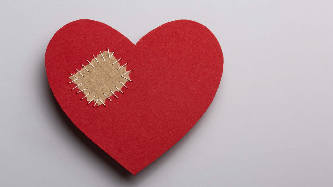 Большое красное сердце с заплаткой на сером фоне