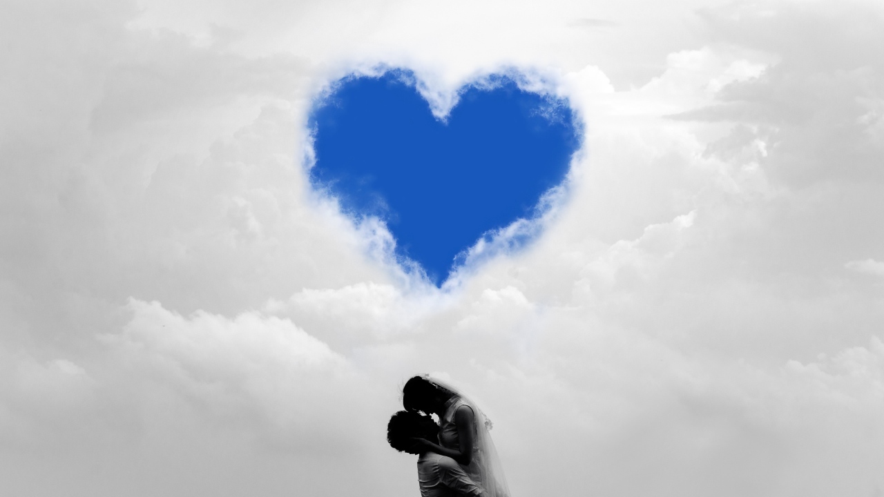 Пара на фоне сердца в небе в белых облаках