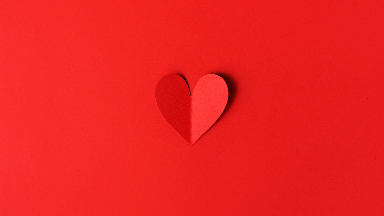 Маленькое бумажное сердце на красном фоне