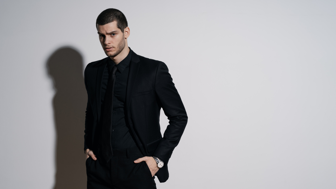 Красивый деловой мужчина стоит у серой стены