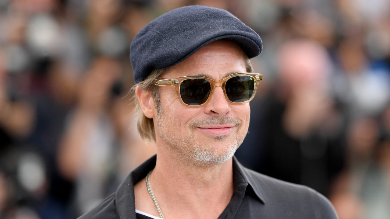 Актер Брэд Питт в кепке и очках