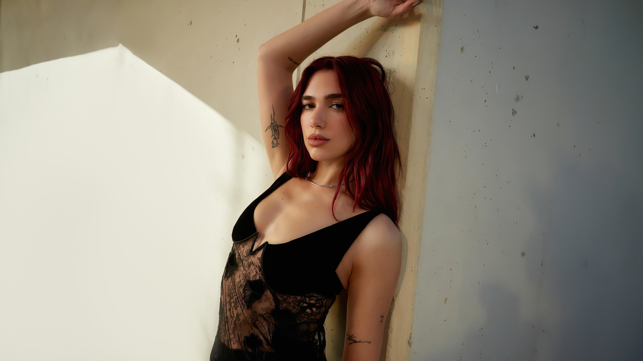 Певица Дуа Липа стоит у стены