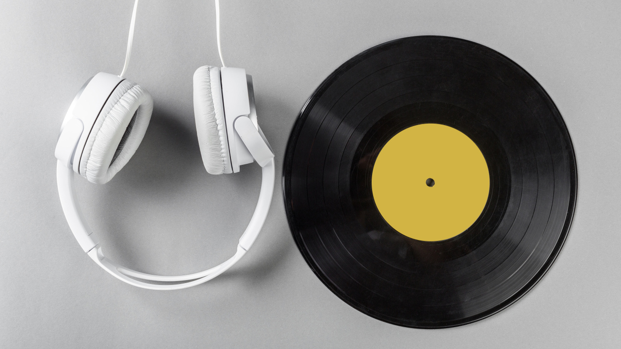 Виниловая пластинка и наушники на сером столе
