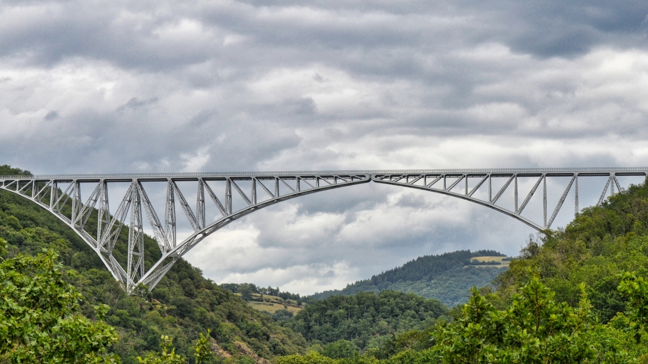 Вид на стальной виадук над покрытыми зеленью горами