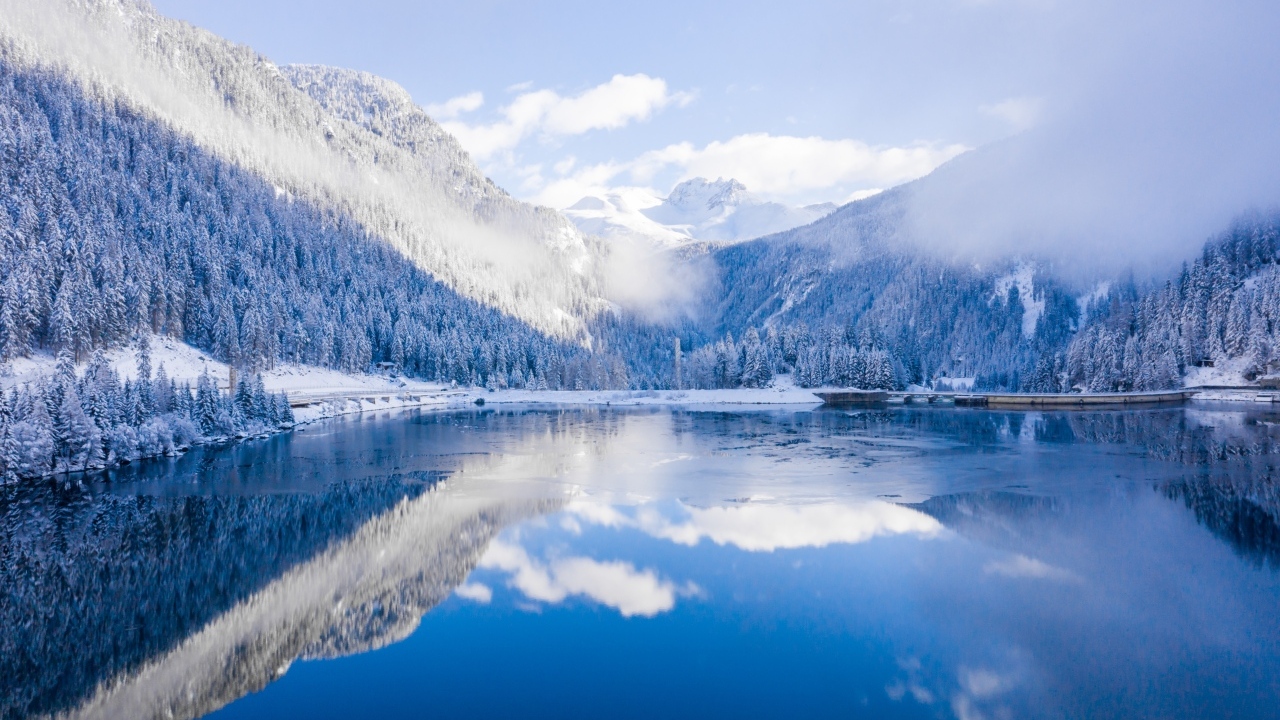 Покрытые снегом горы у покрытого льдом озера