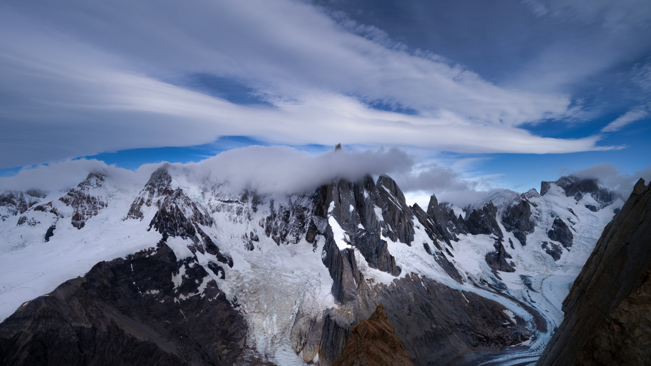 Белые облака над холодными заснеженными горами