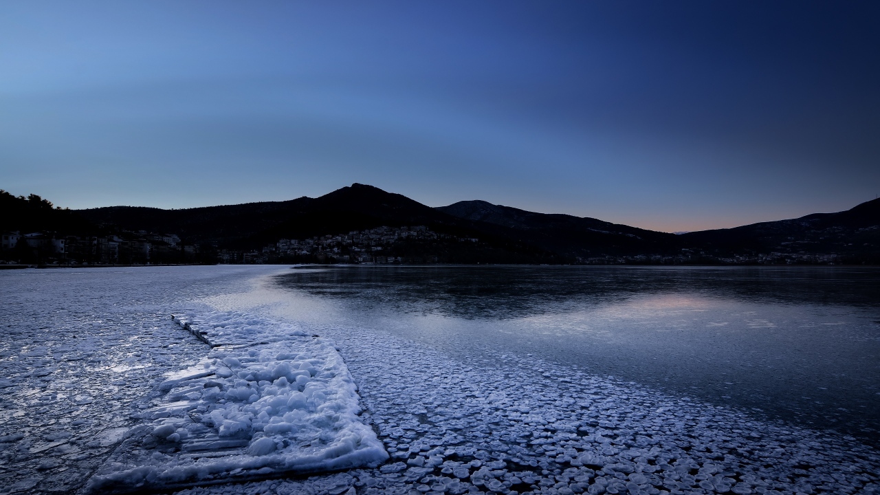 Заледеневшая вода в горном озере в сумерках