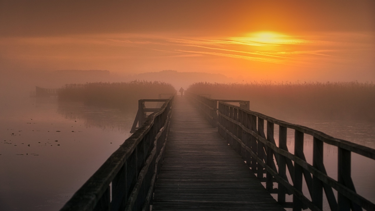 Деревянный мост над рекой на закате