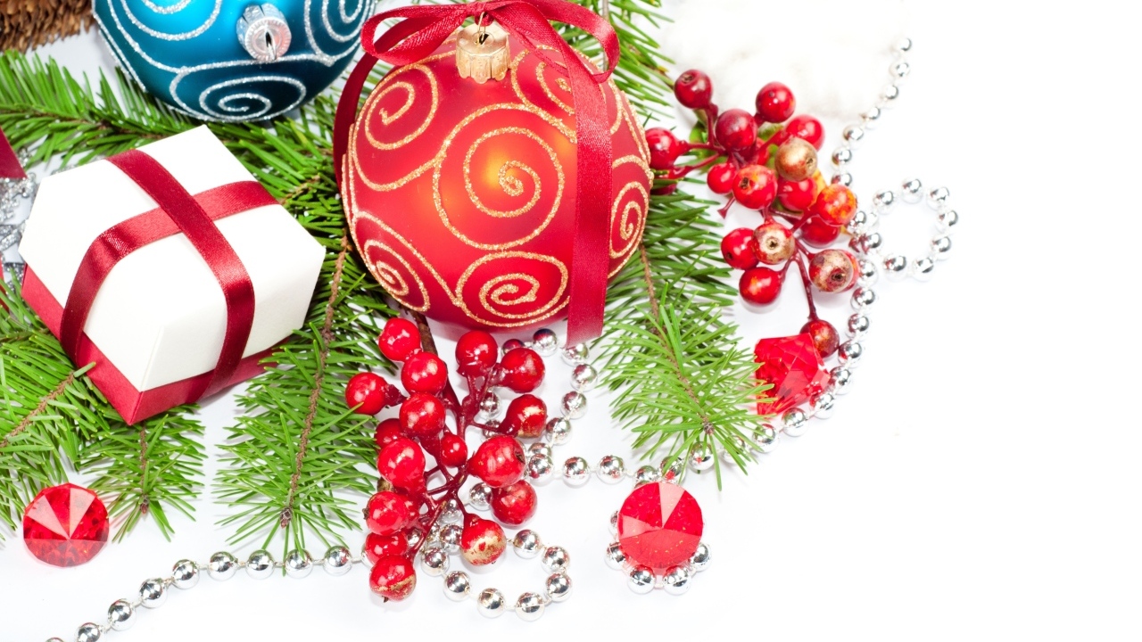 Разноцветные елочные игрушки с ветками на белом фоне