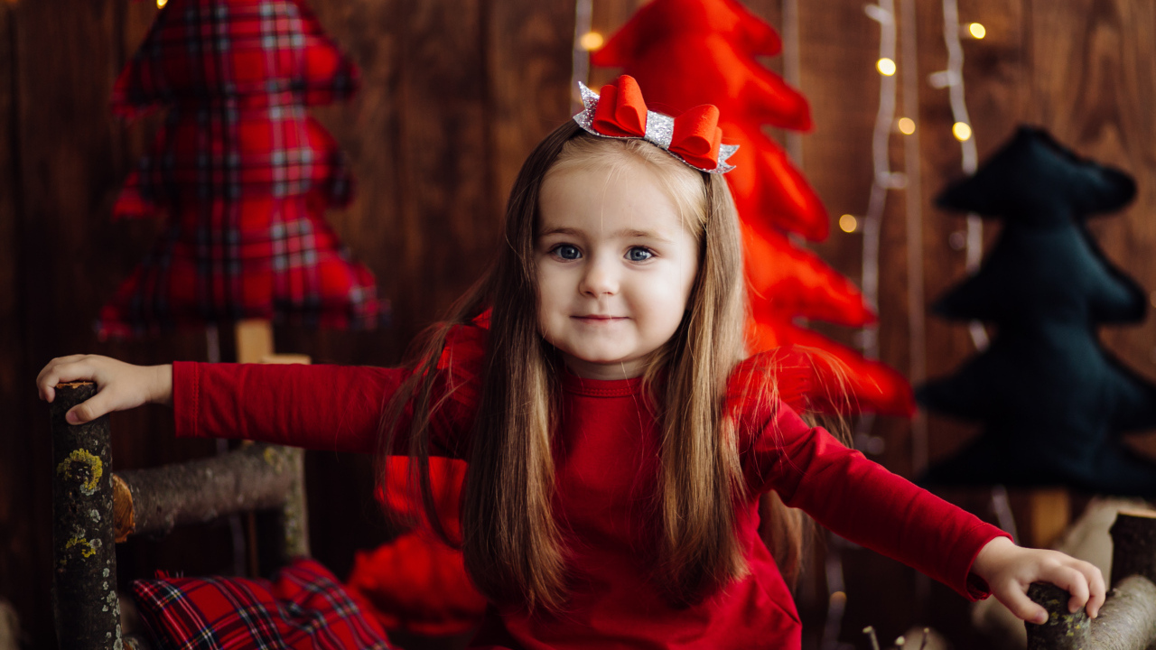 Красивая маленькая длинноволосая девочка в красном платье