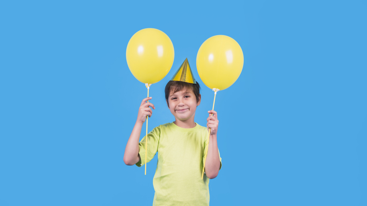 Мальчик на день рождения с желтыми шариками
