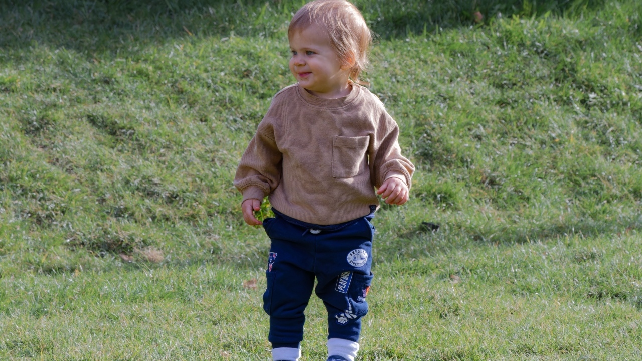 Веселый маленький мальчик гуляет на природе