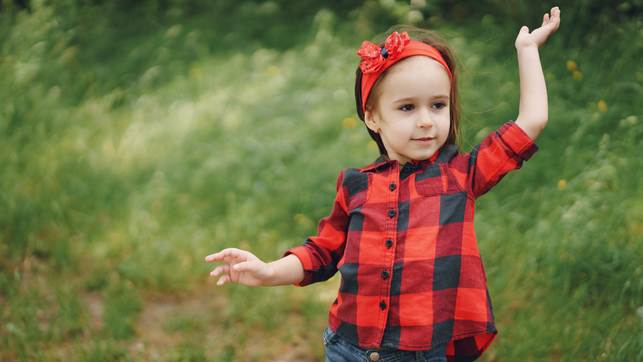 Милая девочка с красным бантом на голове 