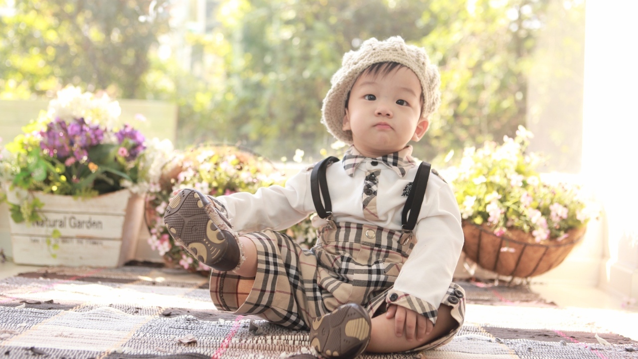 Смешной мальчик азиат у цветов