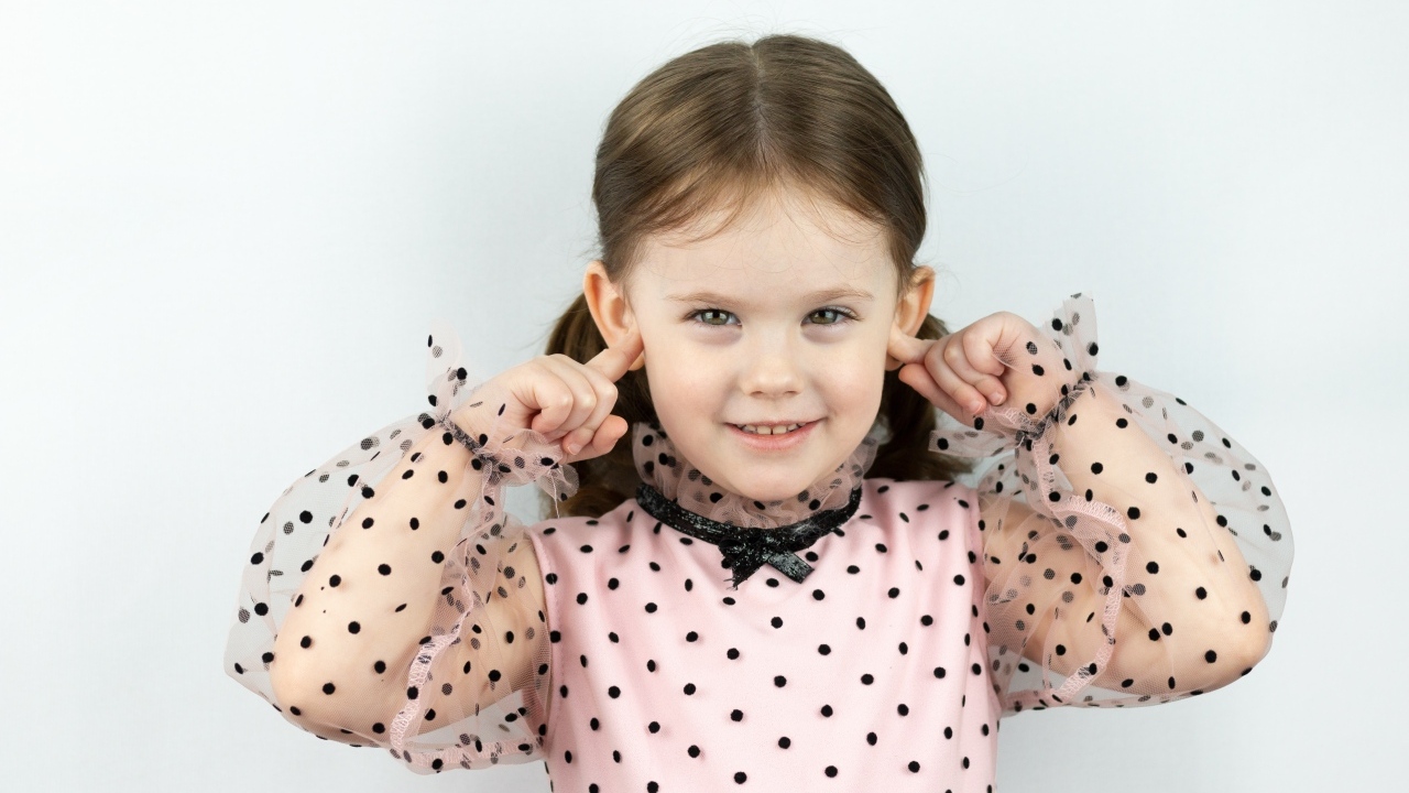 Смешная маленькая девочка закрыла уши