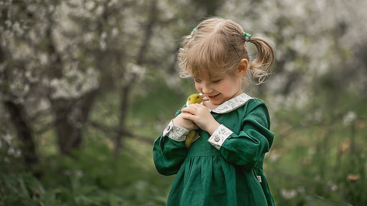 Девочка в зеленом платье с утенком в руках