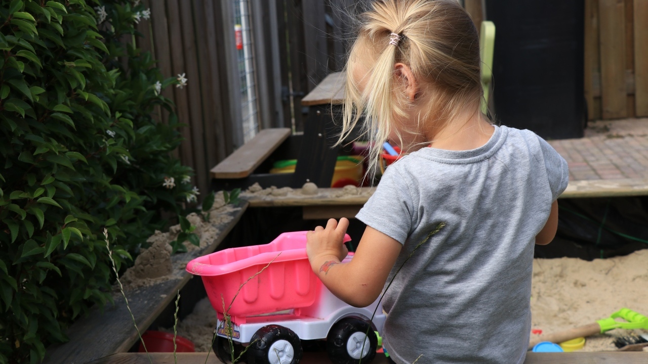 Девочка играет с игрушечной машинкой