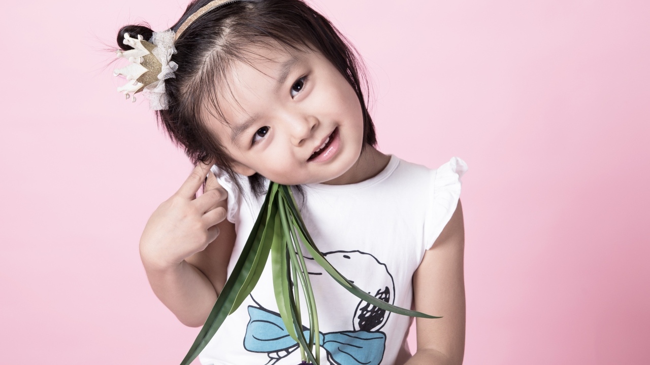 Маленькая девочка азиатка на розовом фоне