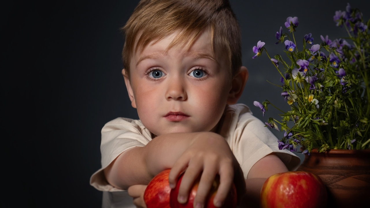 Маленький голубоглазый мальчик с яблоками
