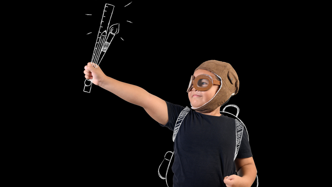 Маленький мальчик с нарисованными кистями на черном фоне