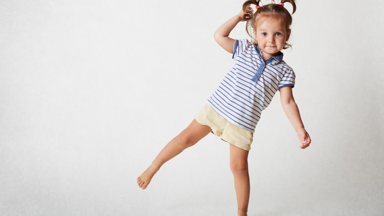 Маленькая девочка на сером фоне