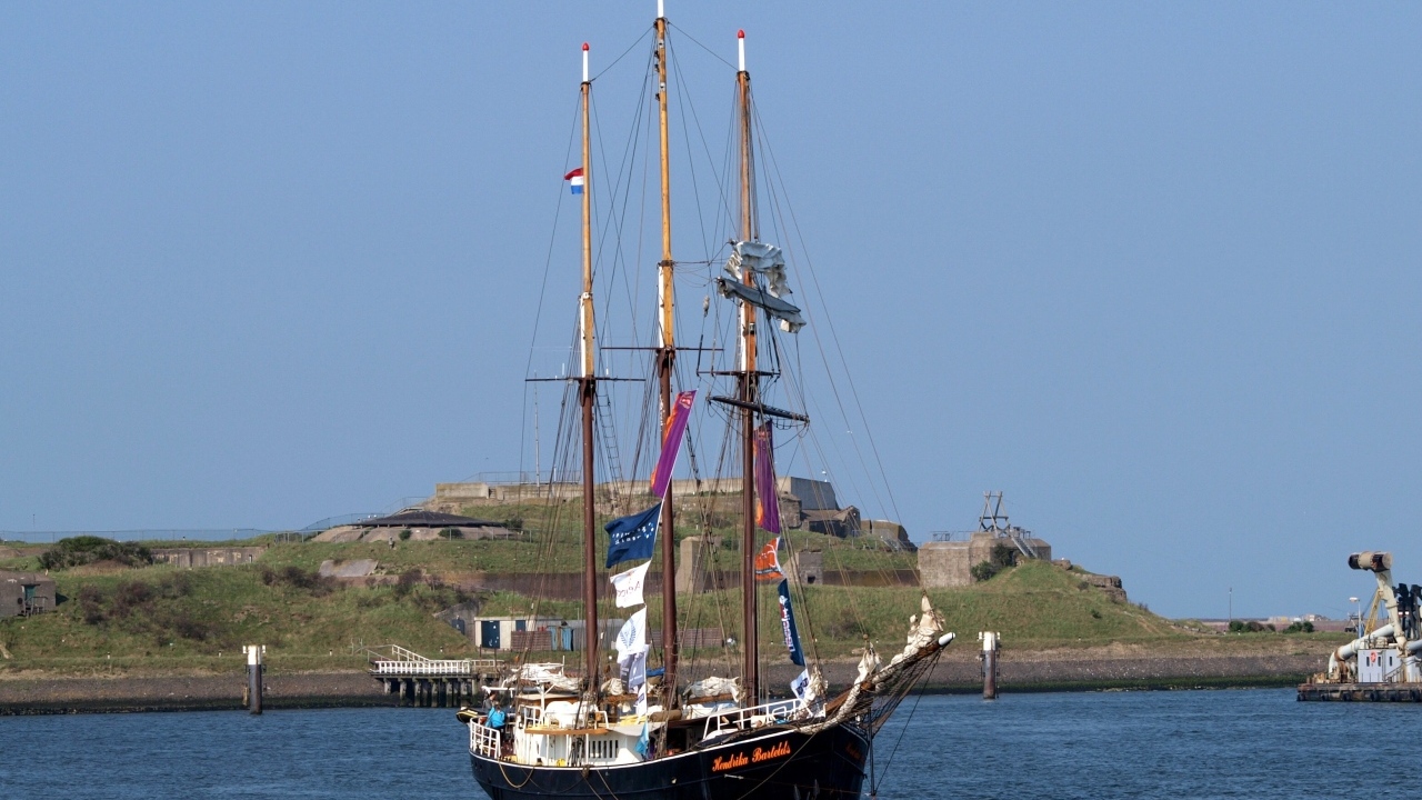 Большой корабль с опущенными парусами в гавани