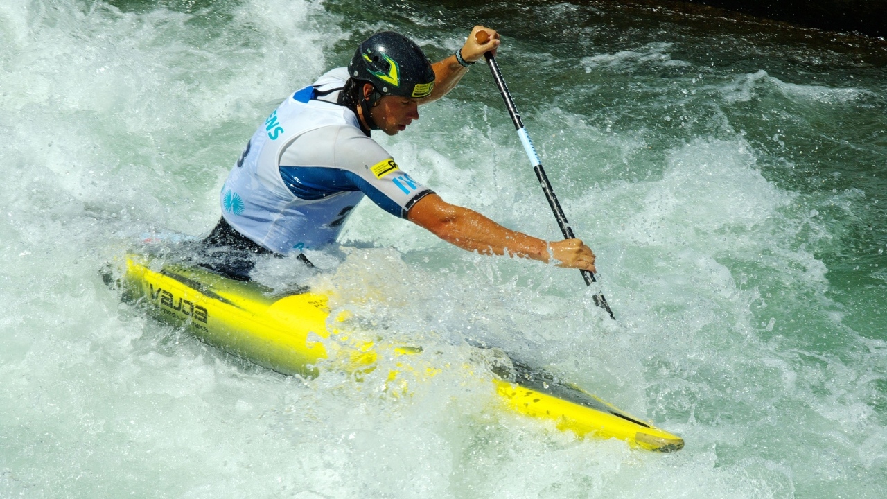Мужчина на байдарке спускается по бурной реке