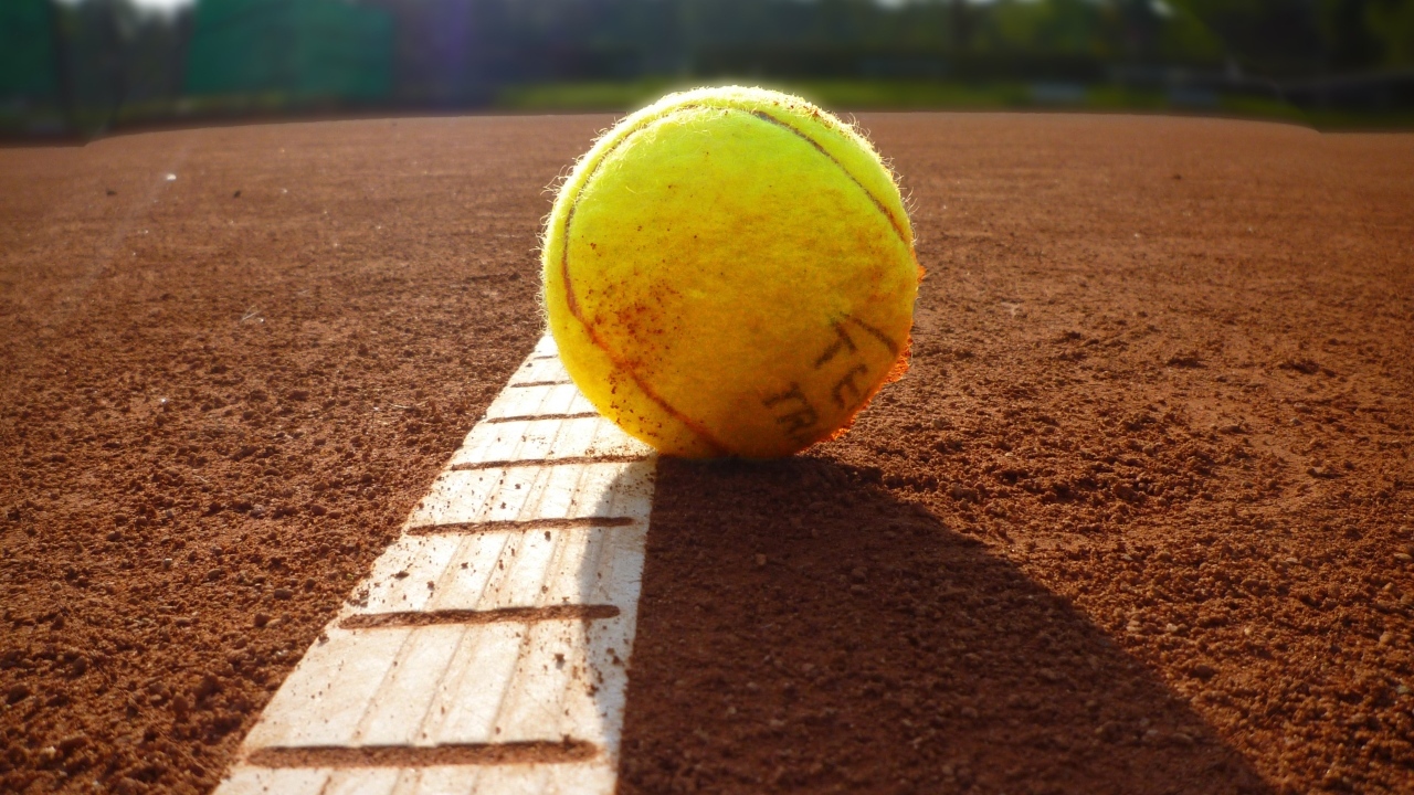 Желтый теннисный мяч лежит на поле