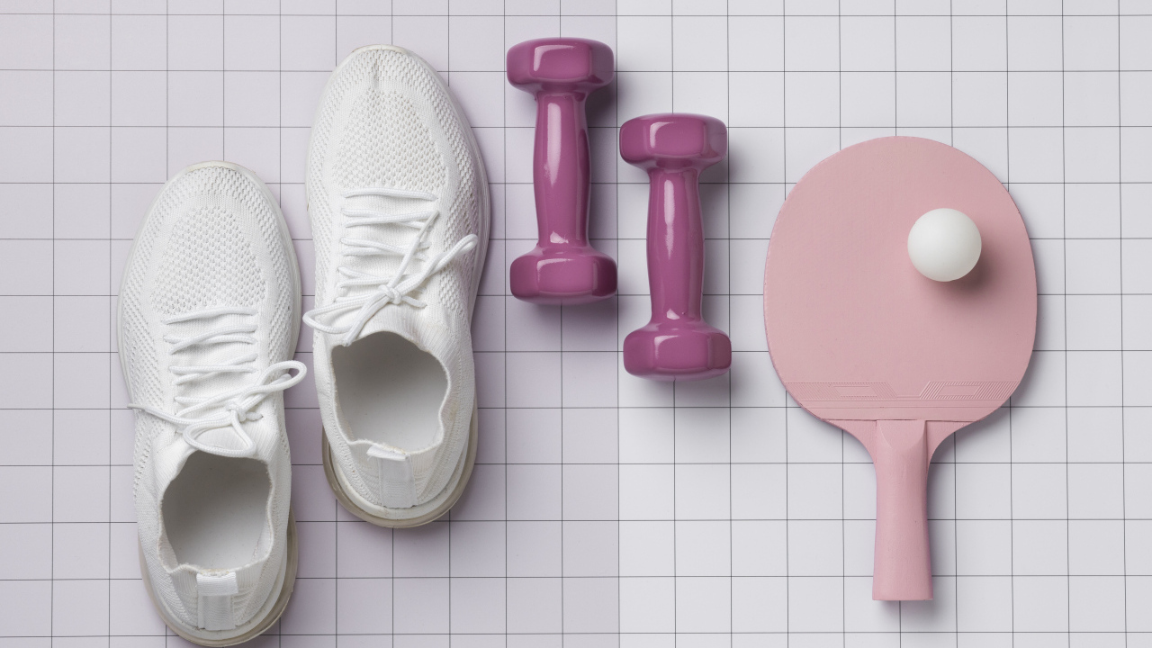 Гантели, ракетка с мячом и кроссовки на клетчатом фоне