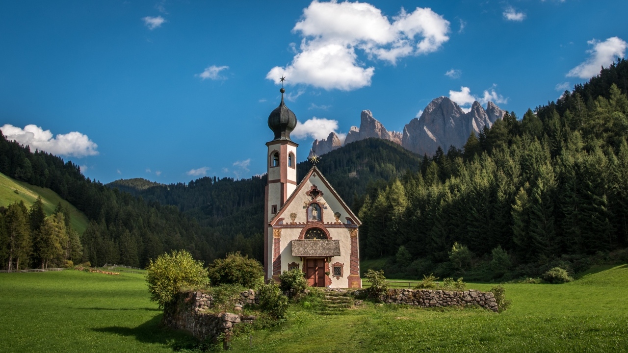 Старая церковь на фоне гор под красивым голубым небом, Италия