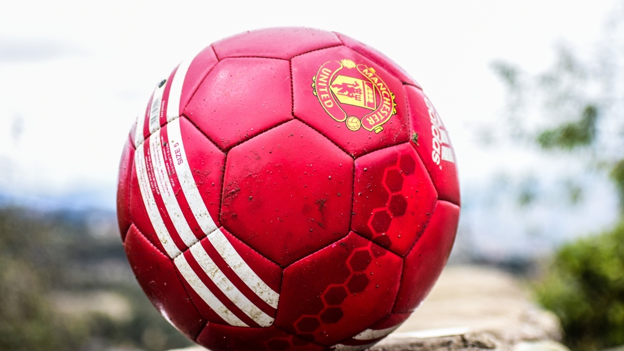 Красный футбольный мяч лежит на камне