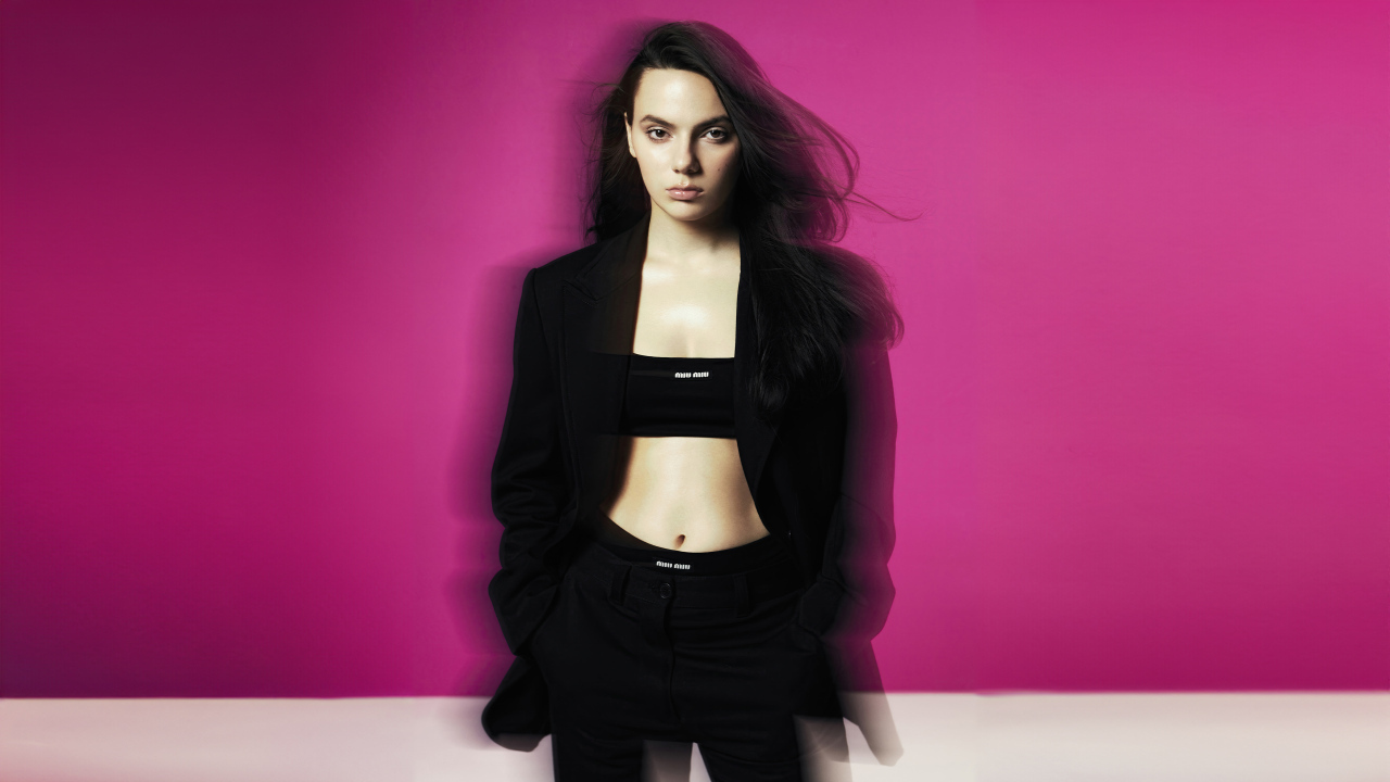 Актриса Дафни Кин стоит у розовой стены